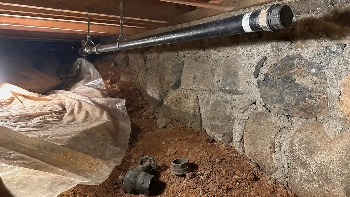 A properly capped and labelled black iron gas line after a conversion, terminated at an accessible point in a mountain-home crawlspace