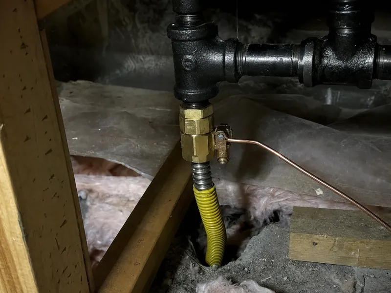 Yellow-jacketed CSST and its bonding clamp in a mountain home, the lightning-protection detail worth checking during any electrical work
