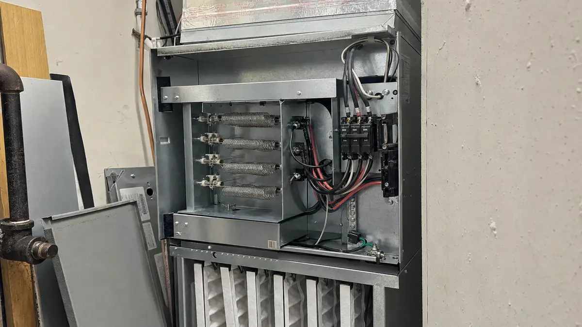 An electric strip heat kit installed in an air handler with its factory breaker block, the largest single load in a converted mountain home