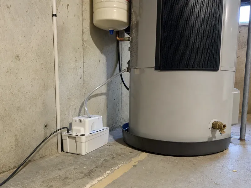 Condensate pump and service clearance at the base of a hybrid water heater, the detail that decides whether a basement placement works