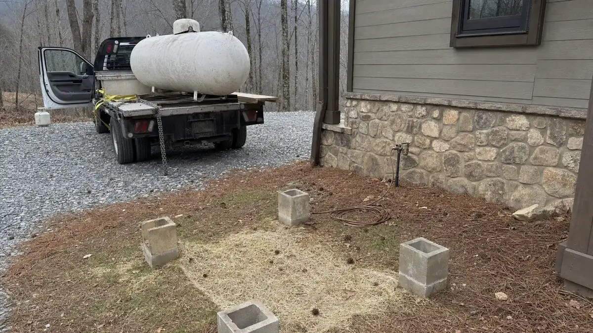 A supplier crew collecting a leased propane tank from a North Georgia mountain property after the heat pump conversion is commissioned