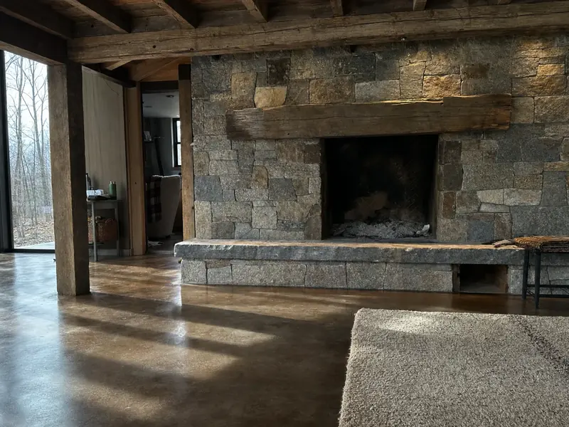 Fieldstone hearth and slab floor in a Pickens County cabin, the thermal mass that decides whether off-peak pre-heating actually saves anything